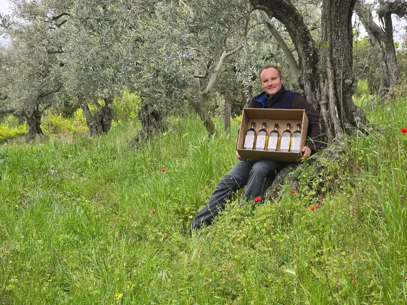 Pierre pr&eacute;sentant le coffret sous un olivier